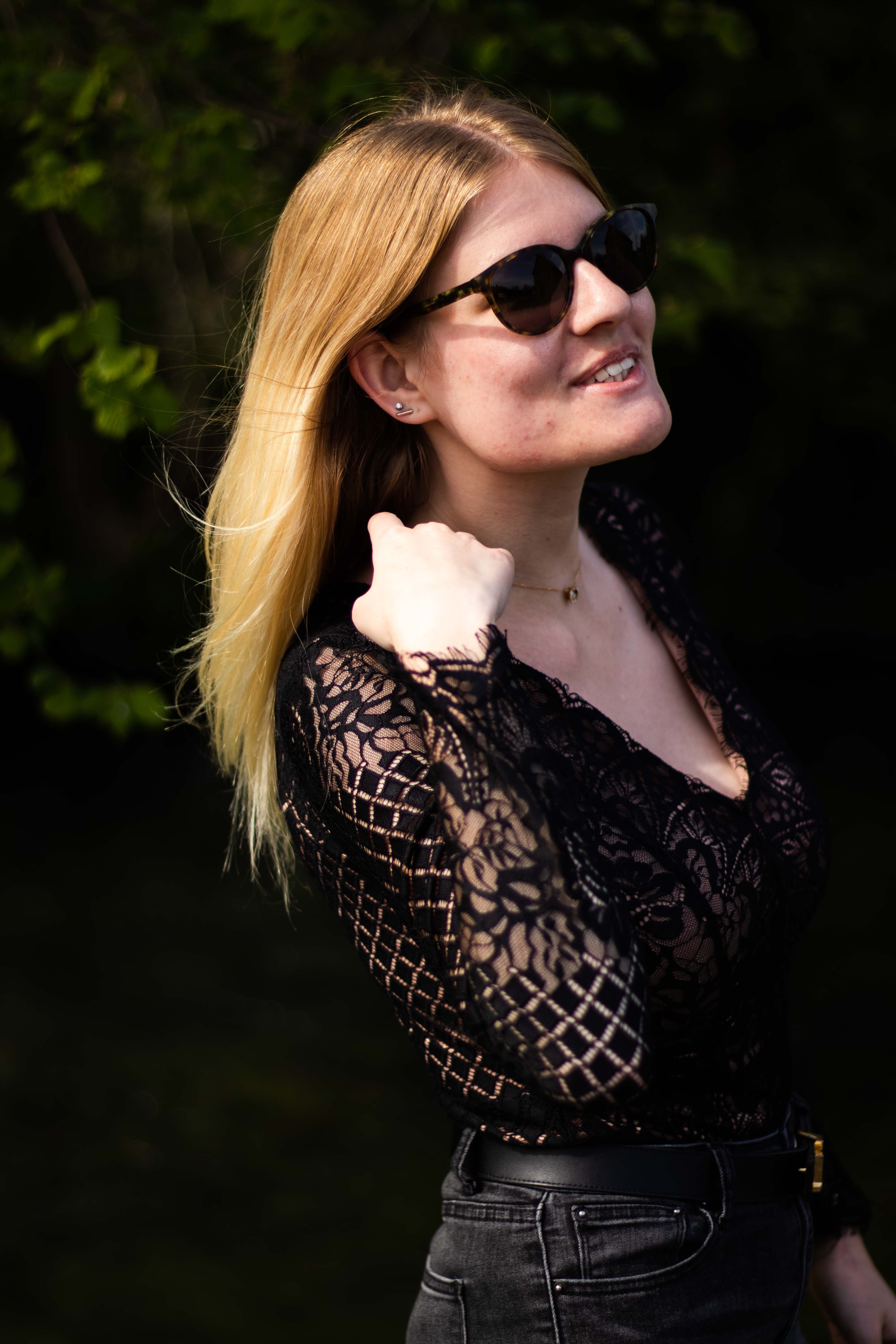 Photo d'une femmme de coté avec des lunettes de soleil relevant ses cheveux